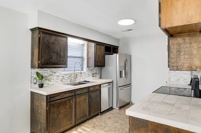 a kitchen with stainless steel appliances a sink and a refrigerator