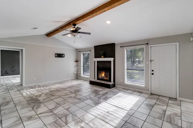 a view of an empty room with window and fireplace