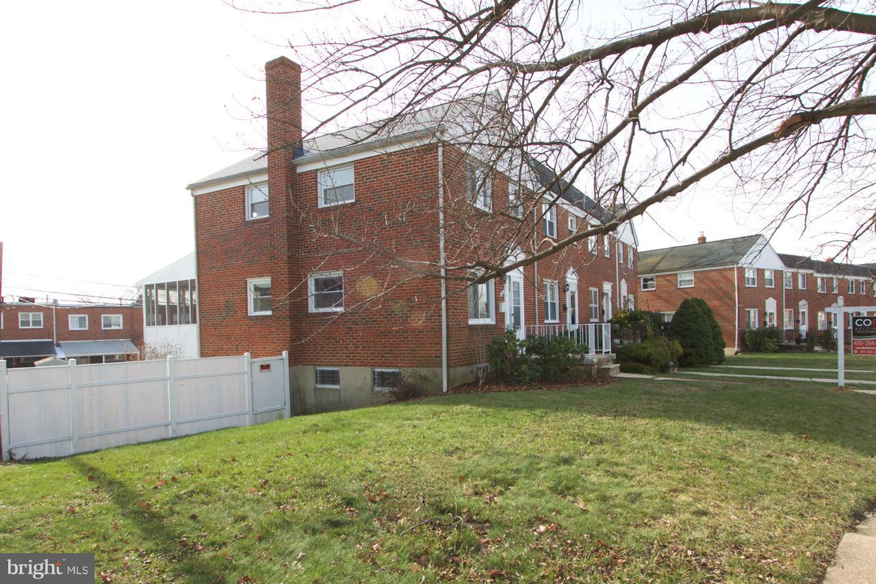 1261 Deanwood Road Baltimore, MD 21234 - Photo 19 of 22 a brick house next to a yard with big trees