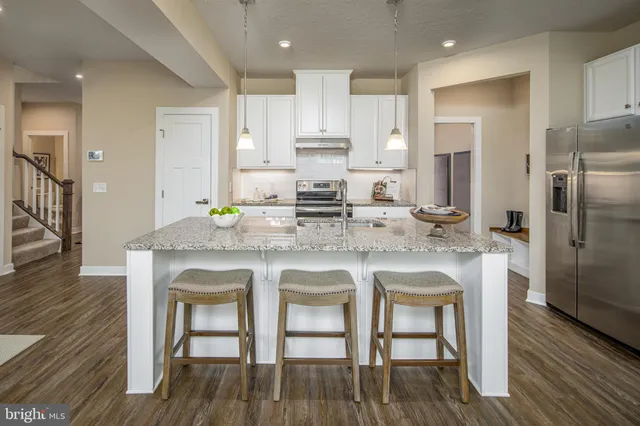a kitchen with granite countertop white cabinets and stainless steel appliances