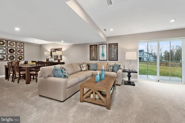 a living room with furniture and a floor to ceiling window