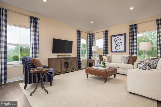 a living room with furniture a large window and a flat screen tv