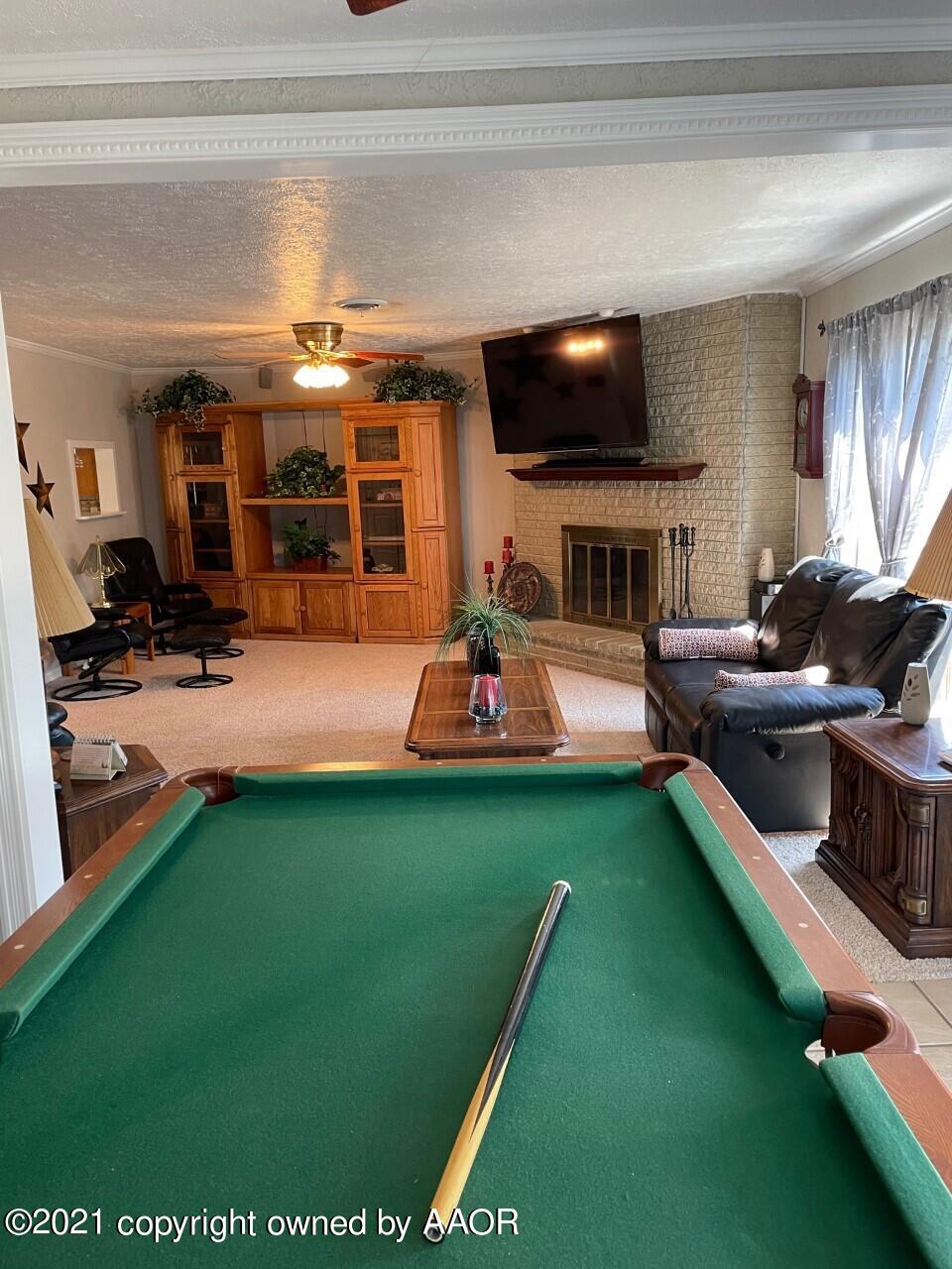 5003 Parker Street Amarillo, TX 79110 - Photo 11 of 20 a living room with furniture a flat screen tv and a fireplace