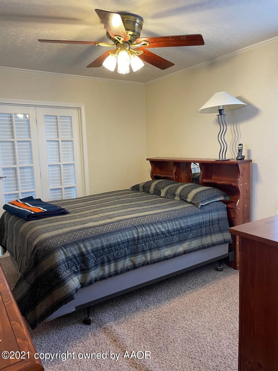 5003 Parker Street Amarillo, TX 79110 - Photo 13 of 20 a bedroom with a bed and a chandelier