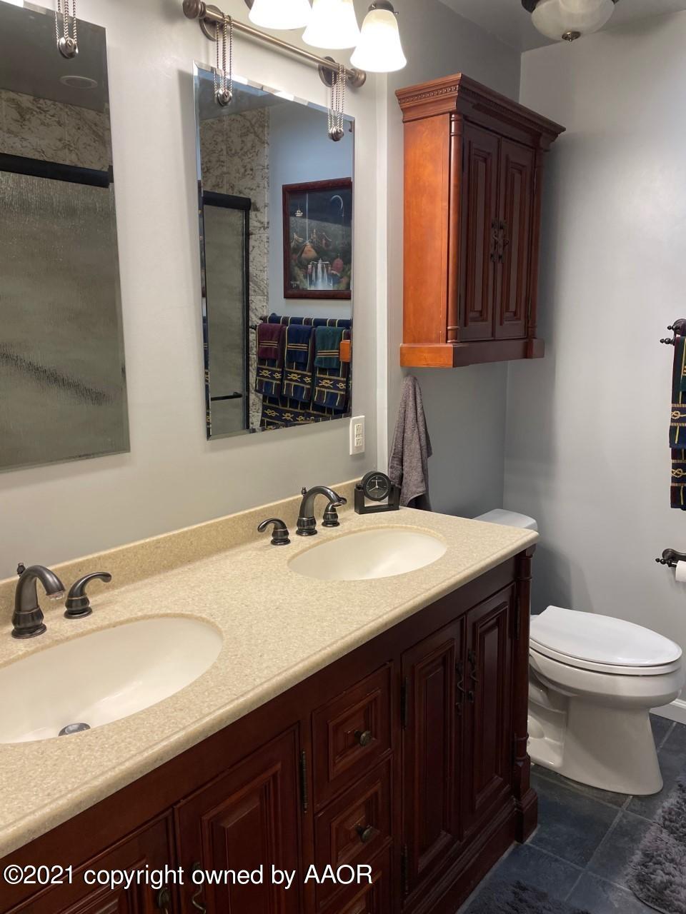 5003 Parker Street Amarillo, TX 79110 - Photo 15 of 20 a bathroom with a granite countertop sink a toilet and mirror