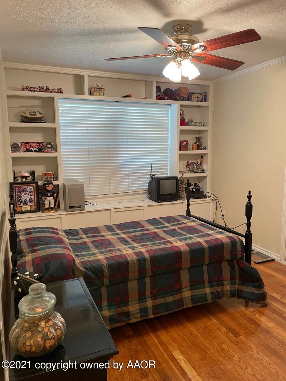5003 Parker Street Amarillo, TX 79110 - Photo 16 of 20 a bedroom with a bed and a chandelier