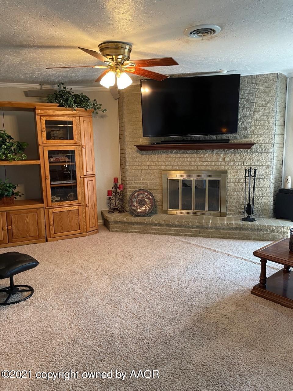 5003 Parker Street Amarillo, TX 79110 - Photo 9 of 20 a living room with a flat screen tv and a fireplace