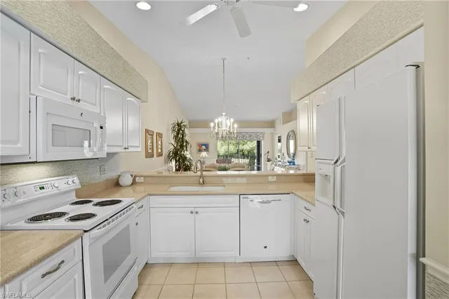 a kitchen with white cabinets and white appliances
