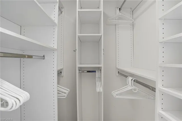 a walk in closet with white walls