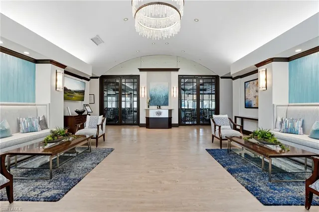 a living room with furniture flowerpot and wooden floor