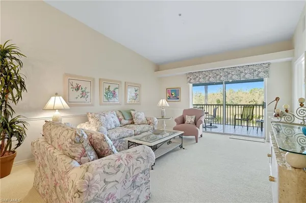 a living room with furniture and a large window with balcony view