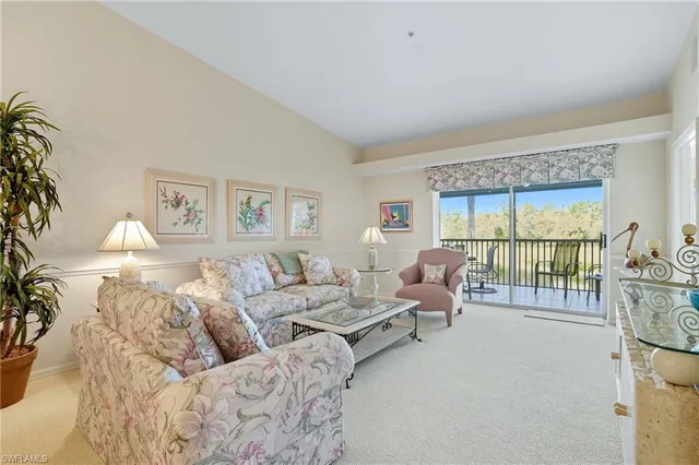 a living room with furniture and a large window with balcony view