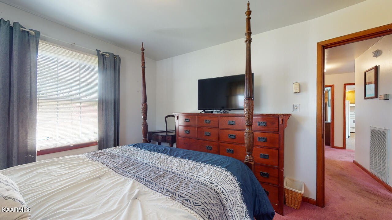 5409 Bluefield Road Knoxville, TN 37921 - Photo 24 of 33 a bedroom with a bed and a flat tv screen on wall