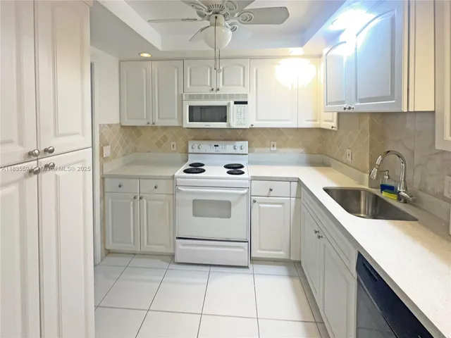 a kitchen with white cabinets stainless steel appliances and sink