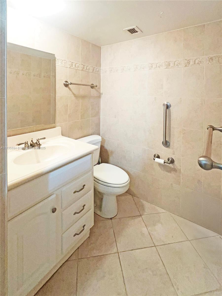 2000 South Ocean Boulevard, Unit 16P Lauderdale-by-the-Sea, FL 33062 - Photo 8 of 31 a bathroom with a granite countertop sink a toilet and a mirror