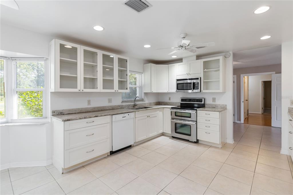 924 Wald Road Orlando, FL 32806 - Photo 19 of 66 a kitchen with granite countertop a stove top oven sink and cabinets