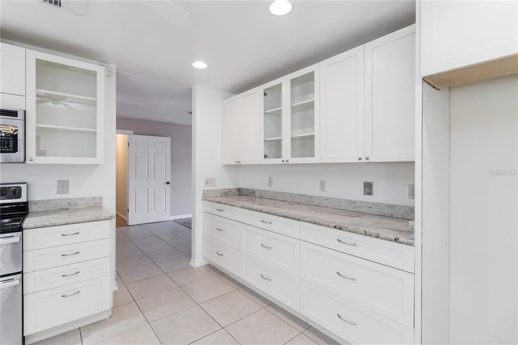 924 Wald Road Orlando, FL 32806 - Photo 20 of 66 a kitchen with granite countertop white cabinets and stainless steel appliances