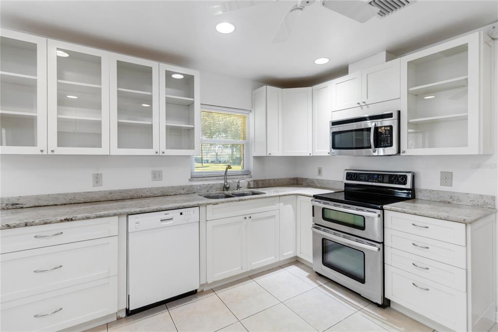 924 Wald Road Orlando, FL 32806 - Photo 22 of 66 a kitchen with granite countertop cabinets stainless steel appliances and a window