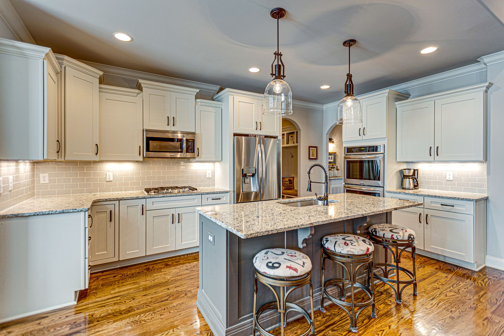 6005 Canberra Court Spring Hill, TN 37174 - Photo 11 of 55 a large kitchen with stainless steel appliances granite countertop a stove a refrigerator a sink a dining table and chairs with wooden floor