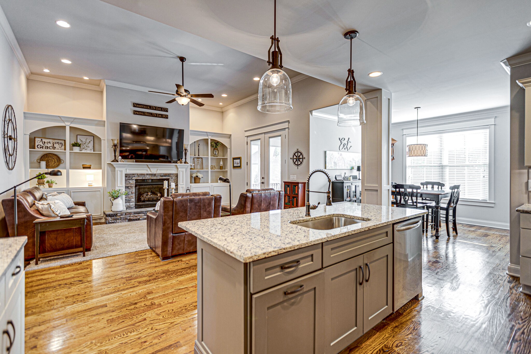 6005 Canberra Court Spring Hill, TN 37174 - Photo 13 of 55 a view of a kitchen counter top space with furniture a kitchen island wooden floor and a view of living room
