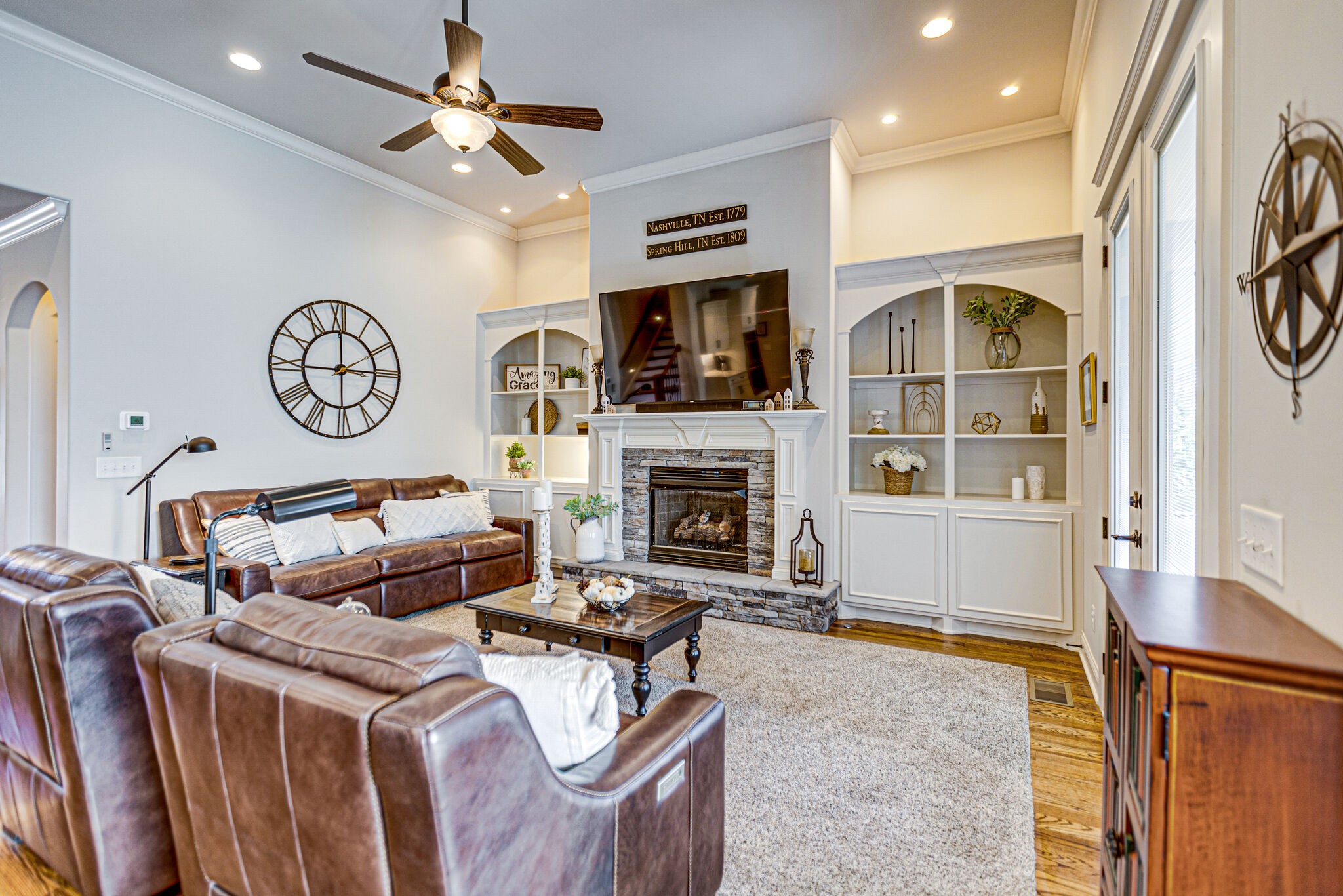 6005 Canberra Court Spring Hill, TN 37174 - Photo 7 of 55 a living room with furniture a flat screen tv and a fireplace