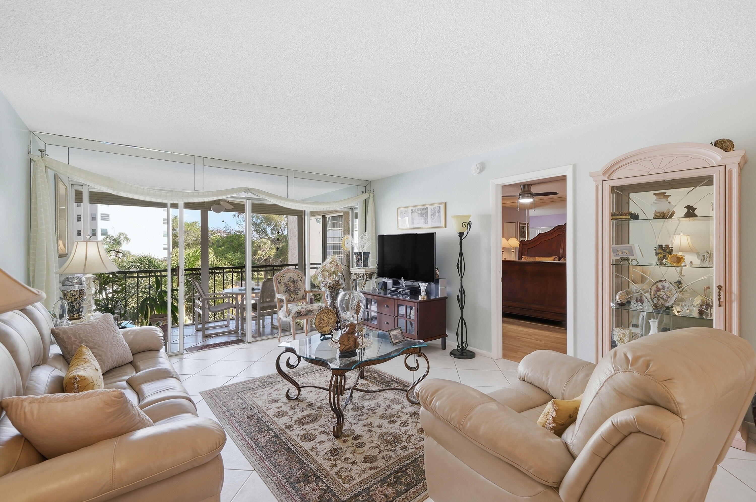 3920 Inverrary Boulevard, Unit 403C Lauderhill, FL 33319 - Photo 12 of 29 a living room with furniture a flat screen tv and a large window