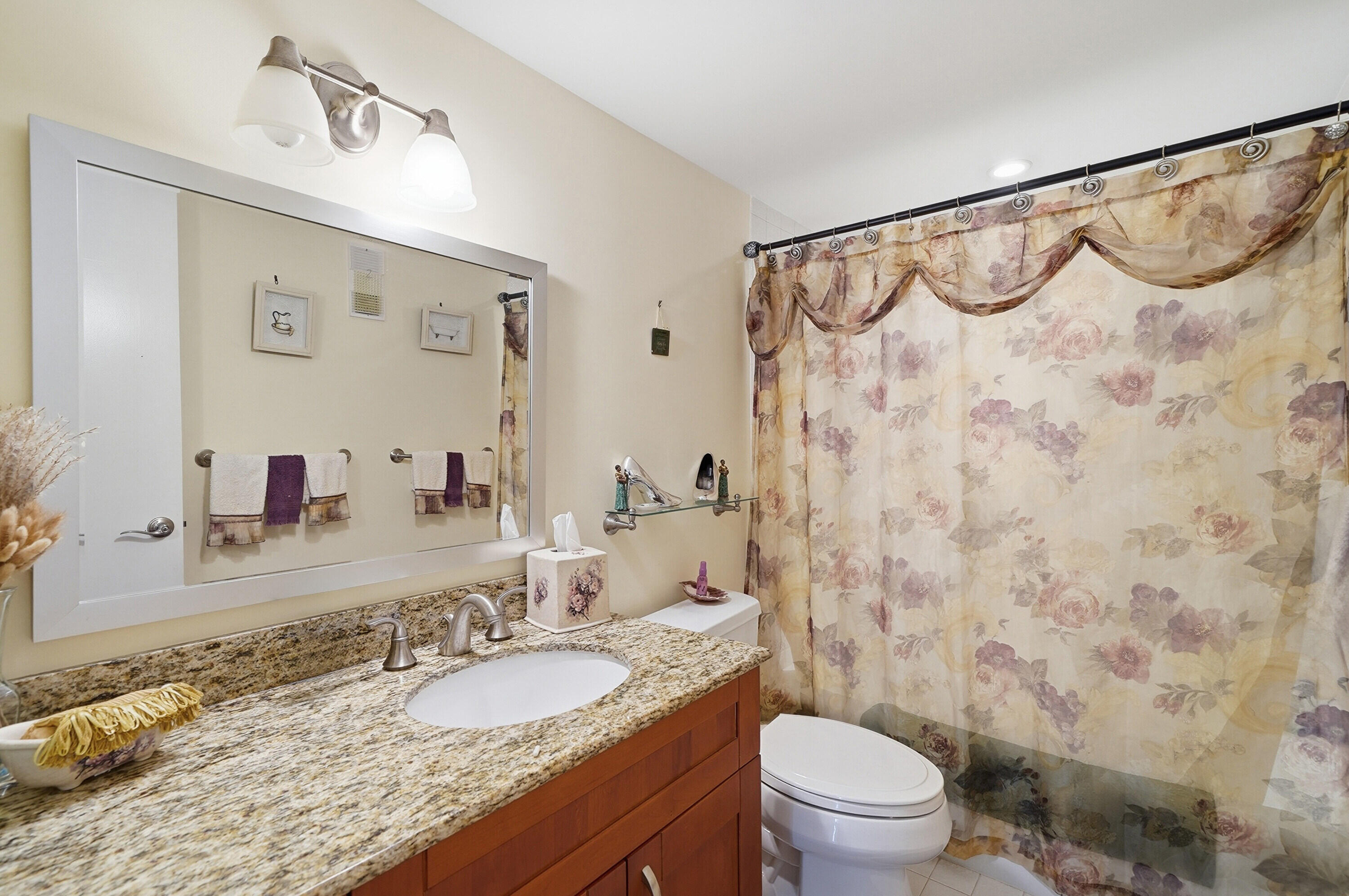 3920 Inverrary Boulevard, Unit 403C Lauderhill, FL 33319 - Photo 17 of 29 a bathroom with a granite countertop sink a toilet and a mirror