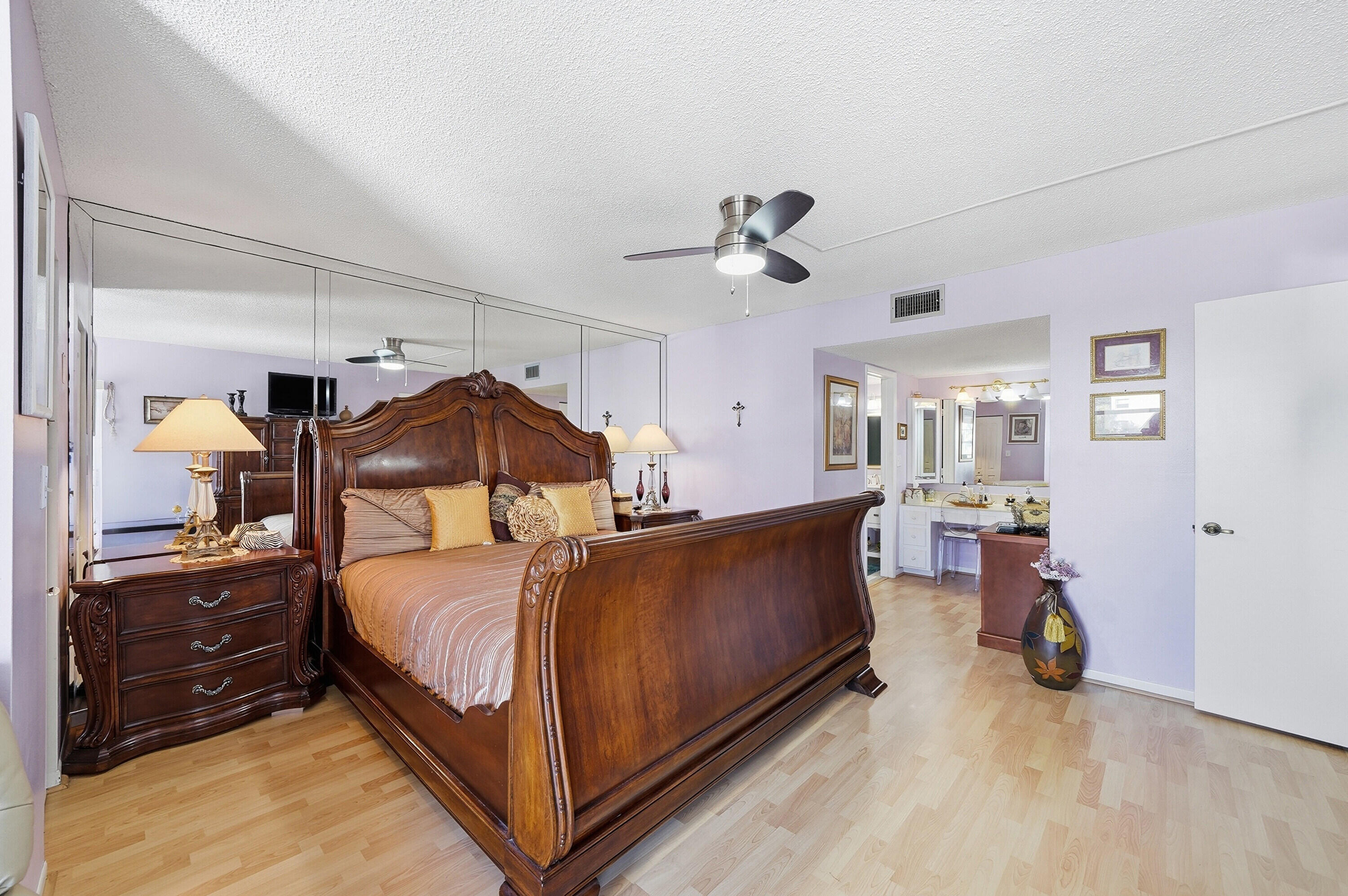 3920 Inverrary Boulevard, Unit 403C Lauderhill, FL 33319 - Photo 21 of 29 a bedroom with a bed and a mirror