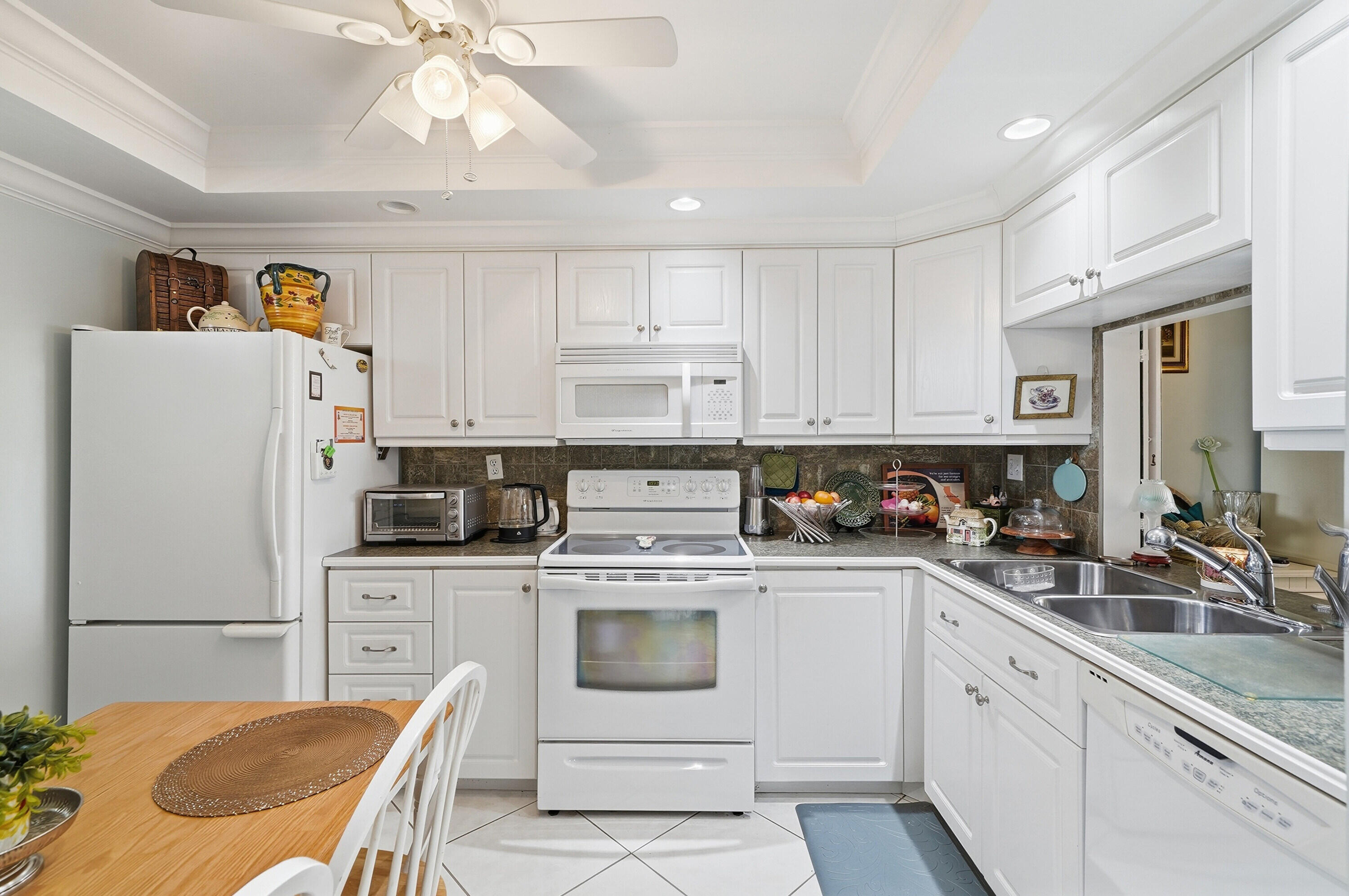 3920 Inverrary Boulevard, Unit 403C Lauderhill, FL 33319 - Photo 6 of 29 a kitchen with a white stove top oven and white cabinets