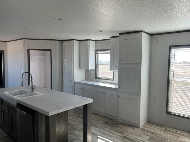 a kitchen with a stove a sink and a window