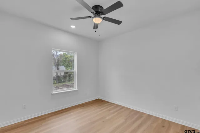 an empty room with a window and a fan