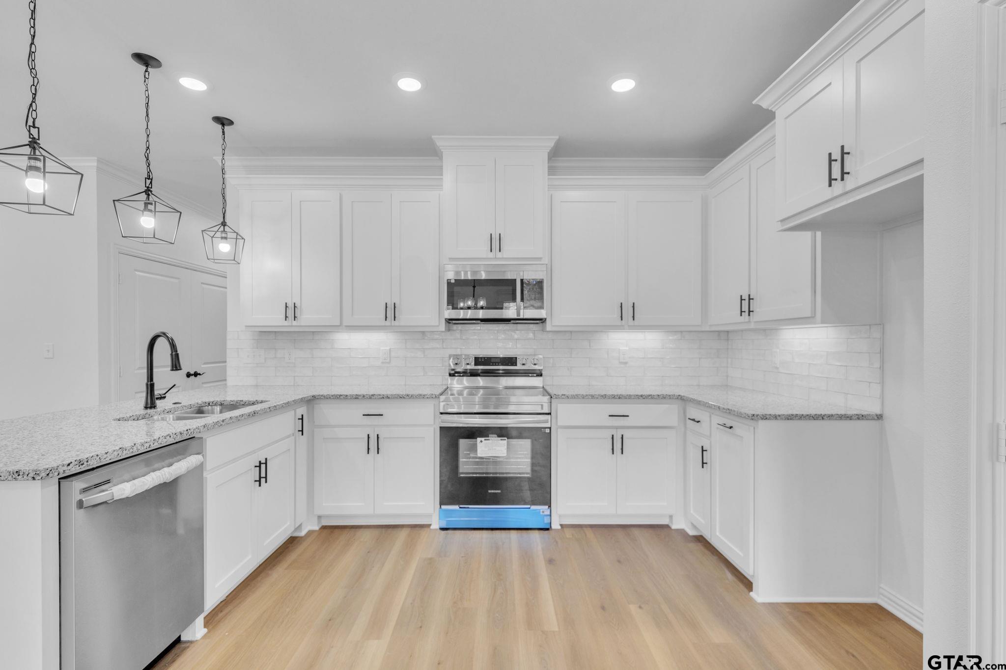 1410 West Connally Street Tyler, TX 75701 - Photo 7 of 29 a kitchen with stainless steel appliances granite countertop a sink stove and refrigerator