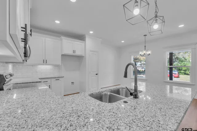 a kitchen with stainless steel appliances granite countertop a sink a stove and a granite counter tops