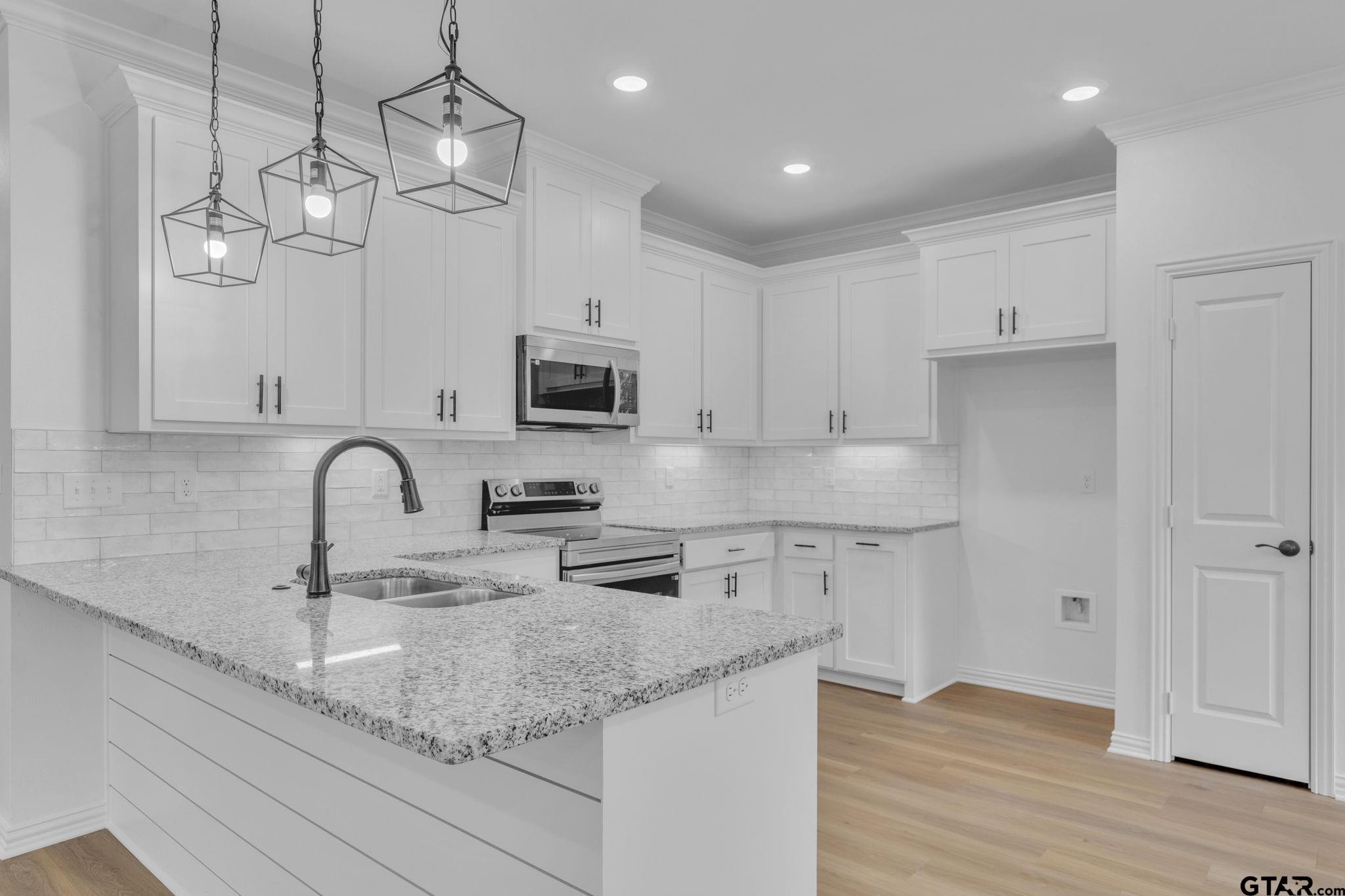 1410 West Connally Street Tyler, TX 75701 - Photo 10 of 29 a kitchen with stainless steel appliances granite countertop a sink a stove top oven a counter space and cabinets