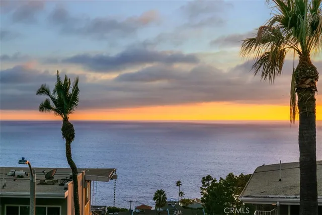 an aerial view of ocean and residential houses with outdoor space