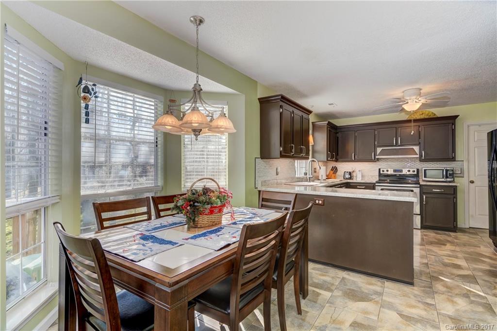 2206 Killarney Place Charlotte, NC 28262 - Photo 8 of 23 a kitchen with a dining table chairs and refrigerator