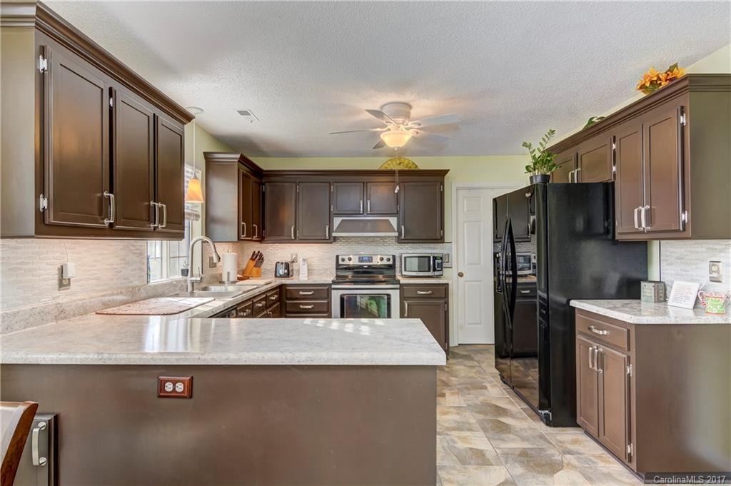 2206 Killarney Place Charlotte, NC 28262 - Photo 9 of 23 a kitchen with kitchen island granite countertop a sink counter top space appliances and cabinets