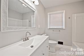1404 Nottingham Road Kannapolis, NC 28081 - Photo 27 of 30 a bathroom with a toilet sink and mirror