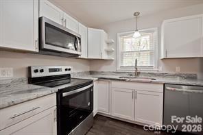 1404 Nottingham Road Kannapolis, NC 28081 - Photo 7 of 30 a kitchen with granite countertop white cabinets stove top oven and microwave