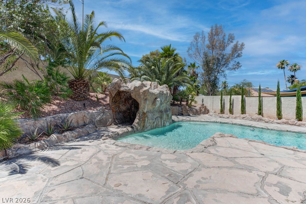 1 Rising Sun Court Henderson, NV 89074 - Photo 42 of 47 A private desert oasis features a custom rock grotto and sparkling blue water for endless relaxation.