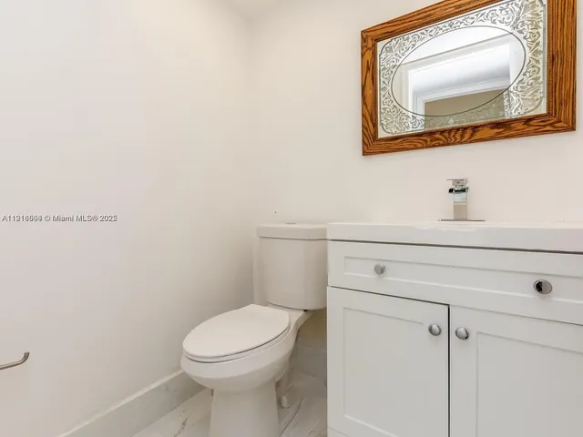 a bathroom with a toilet a sink and mirror