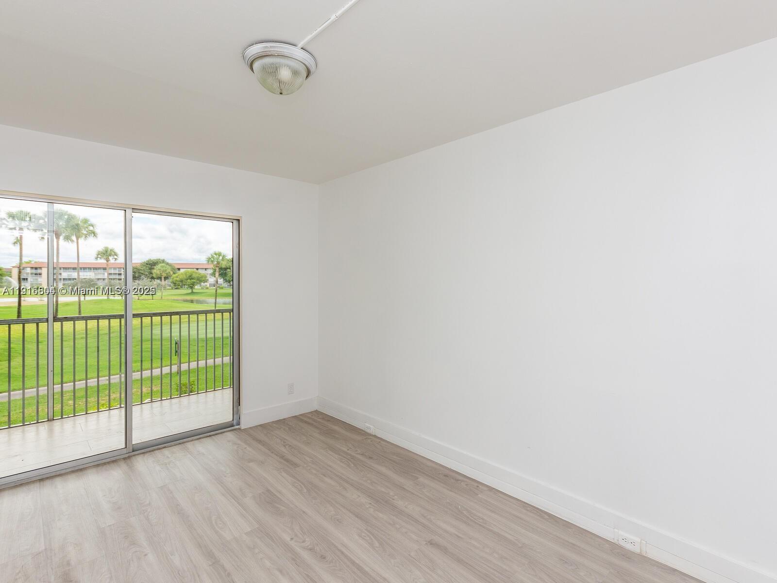 850 Southwest 133rd Terrace, Unit 206B Pembroke Pines, FL 33027 - Photo 9 of 9 a view of a room with wooden floor and windows