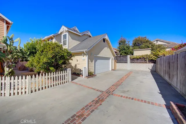 a view of a house with a small yard and wooden fence