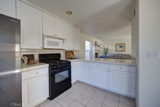 a kitchen with white cabinets and appliances