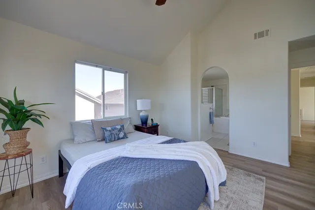 a bedroom with a large bed and a potted plant