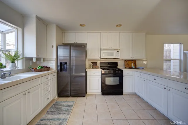 a kitchen with a refrigerator sink and cabinets