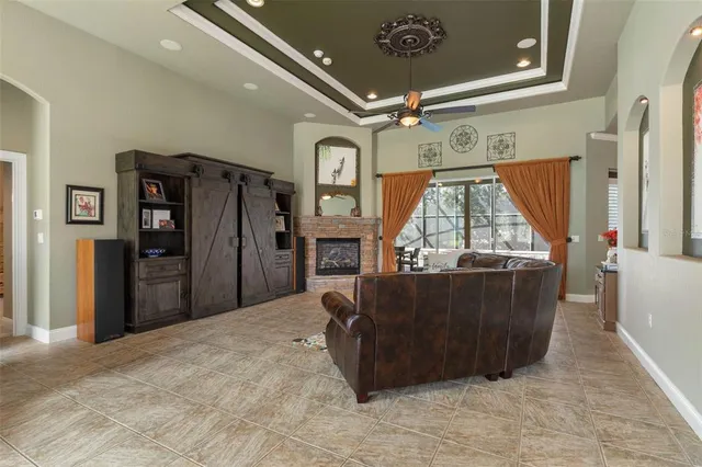 a living room with furniture a fireplace and a chandelier