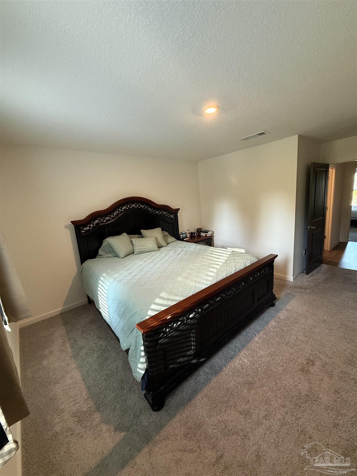 9279 3 Hollow Road Jay, FL 32565 - Photo 37 of 42 a bed sitting in a room next to a lamp