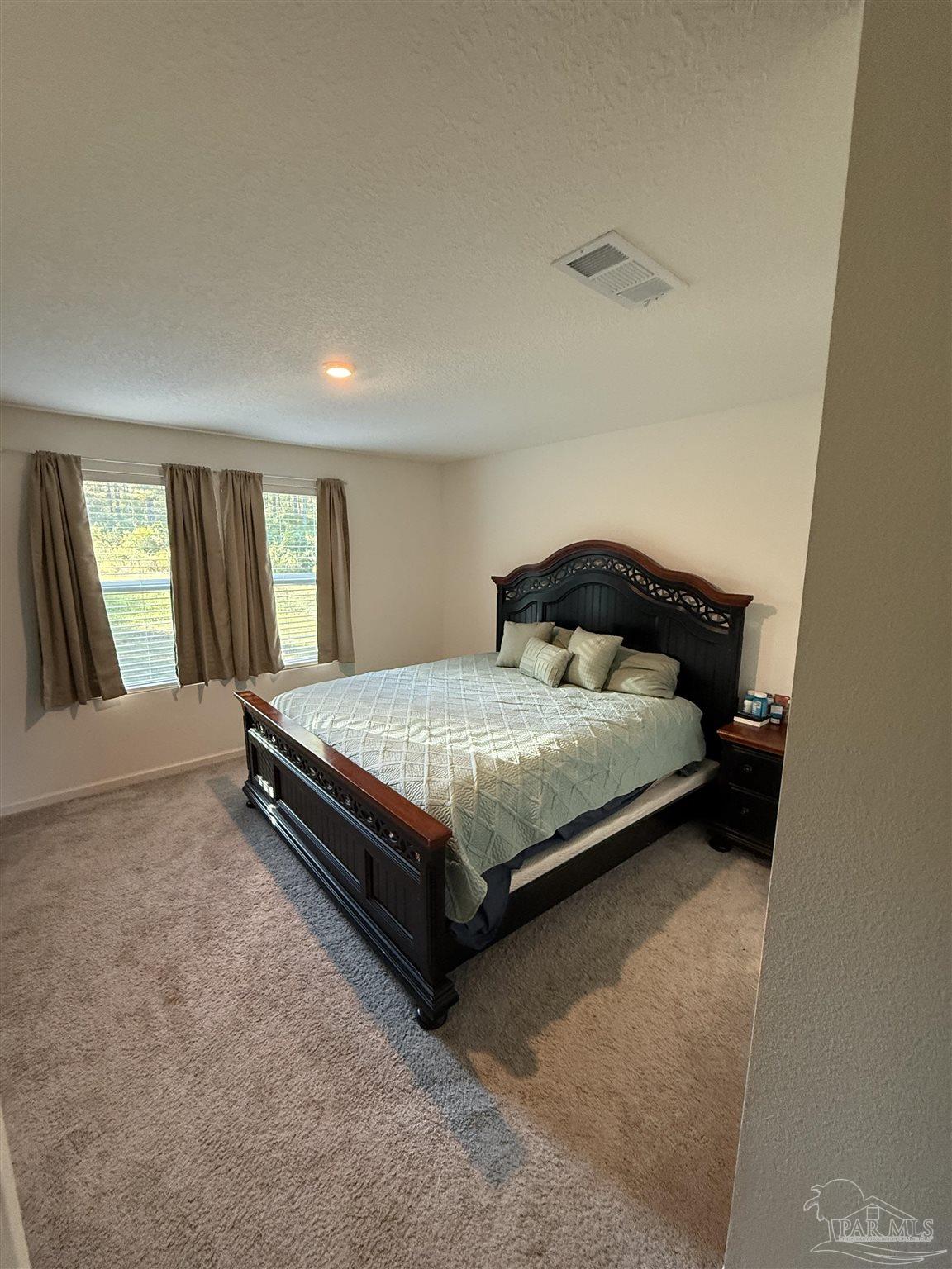 9279 3 Hollow Road Jay, FL 32565 - Photo 38 of 42 a bedroom with a bed lamp and a large window