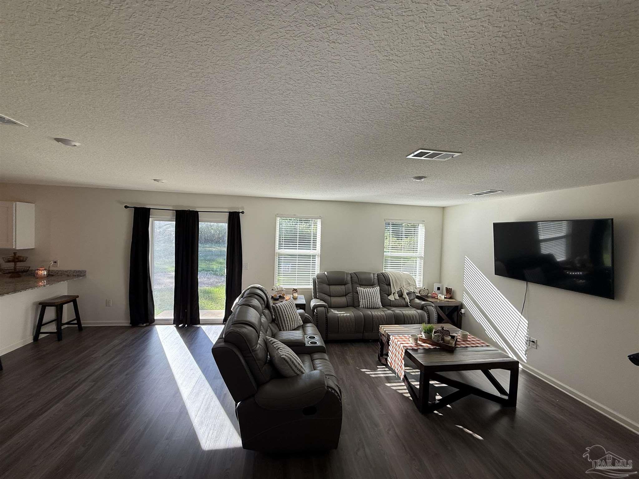 9279 3 Hollow Road Jay, FL 32565 - Photo 4 of 42 a living room with furniture flat screen tv and large window